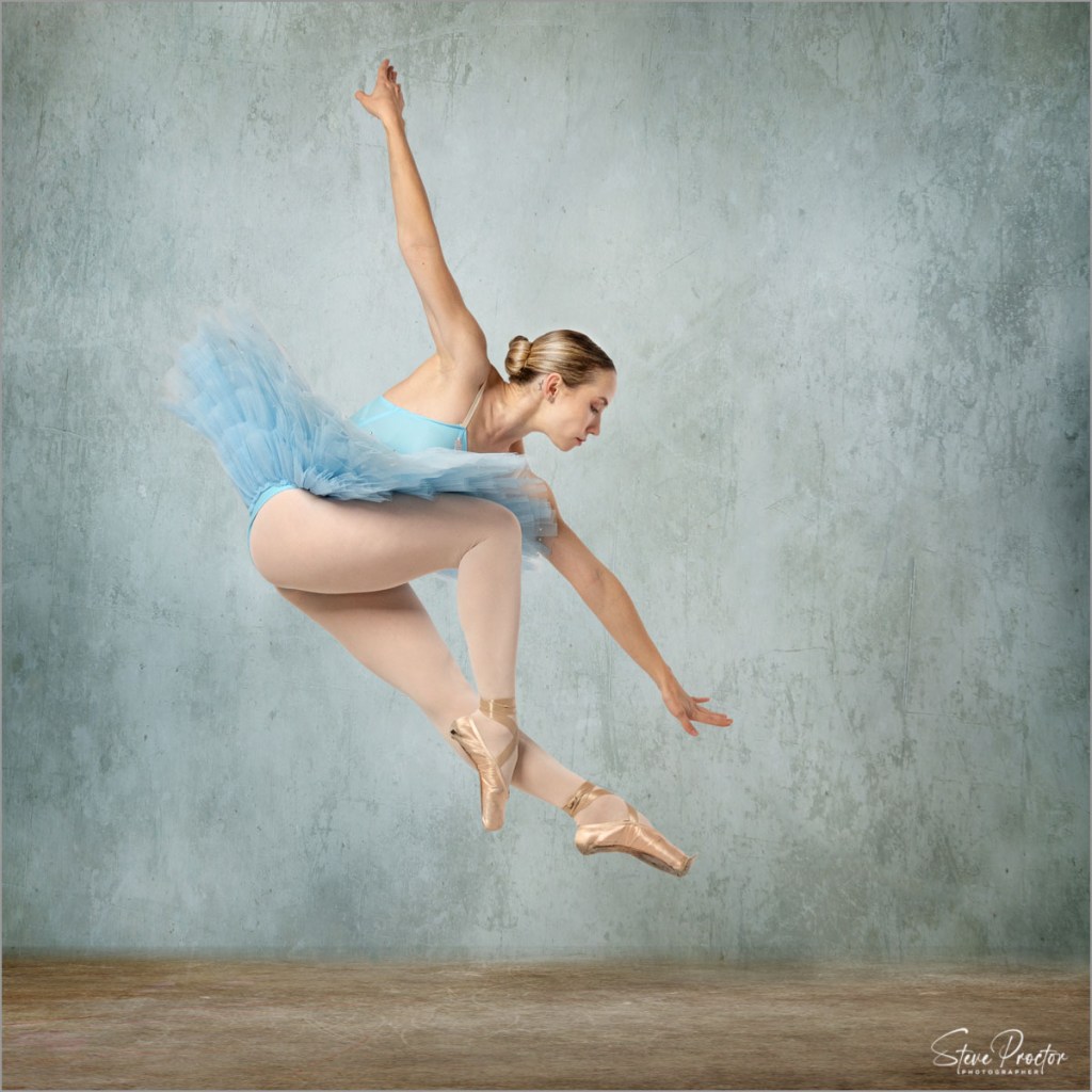 Ballerina in light blue tutu in mid air